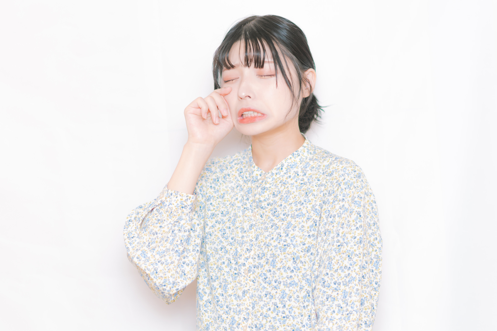 目もとをぬぐって泣いている女性