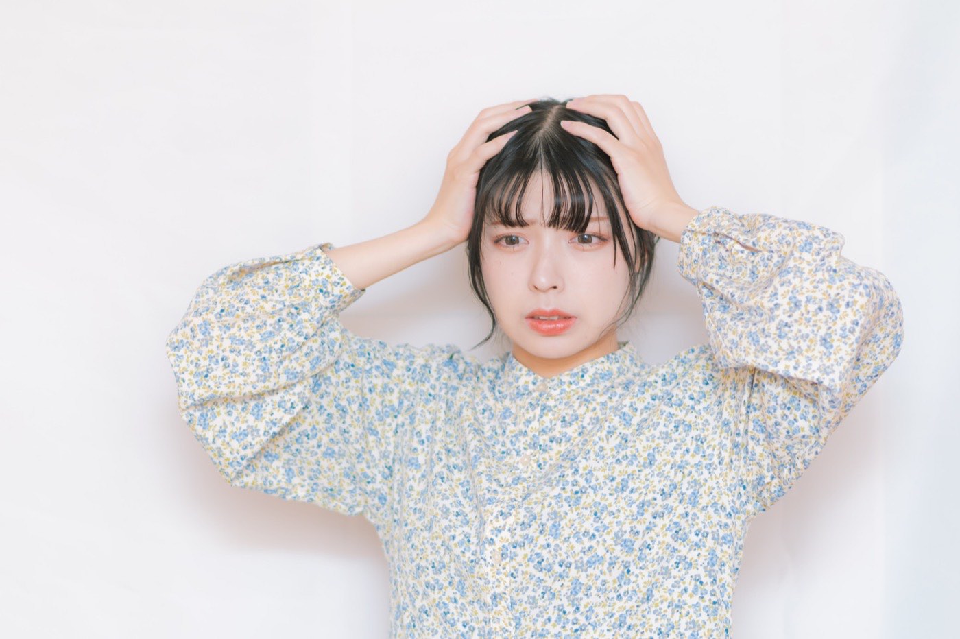 予定を思い出せず、頭を抱える女性
