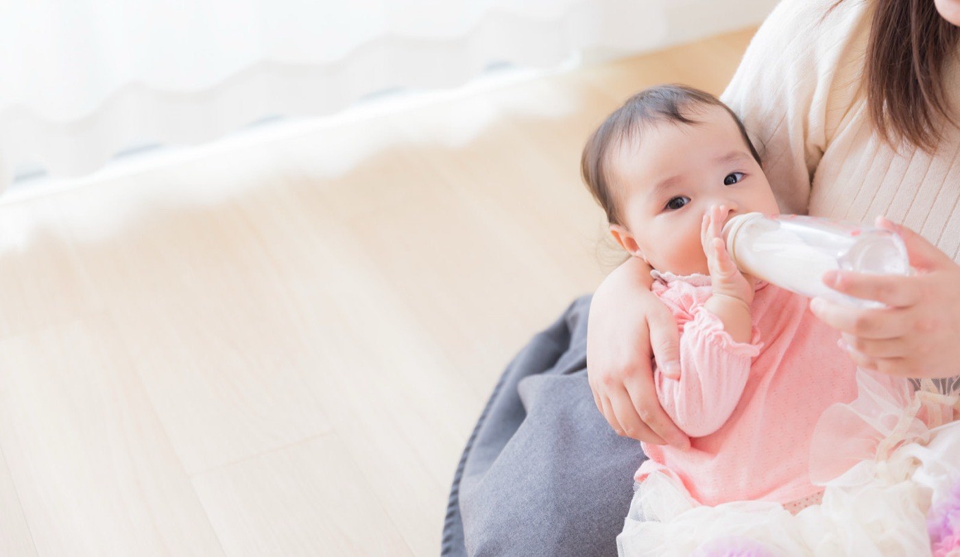 ミルクを飲む赤ちゃんと、支える母親の腕