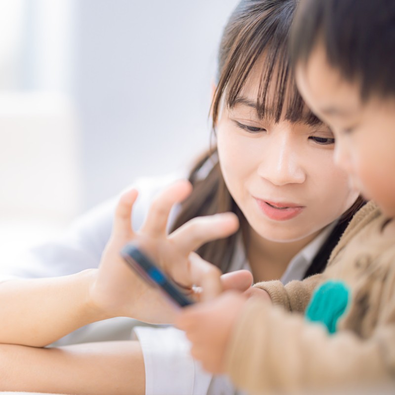 子どもを抱きよせて、一緒に画面をのぞきこむママ