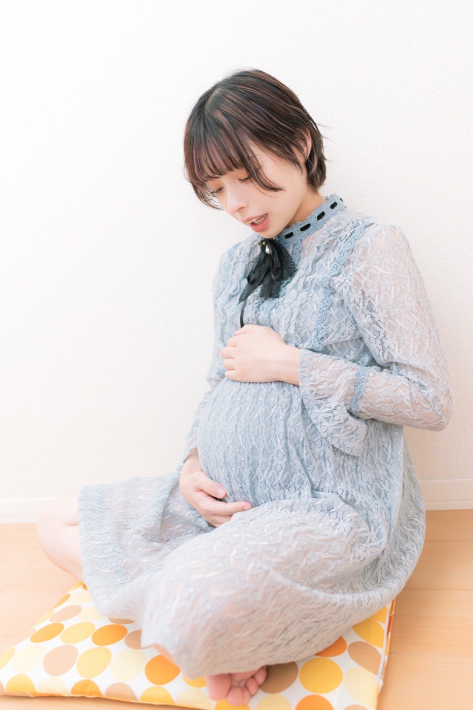 臨月のおなかに手を当て、胎動を感じる妊婦さん