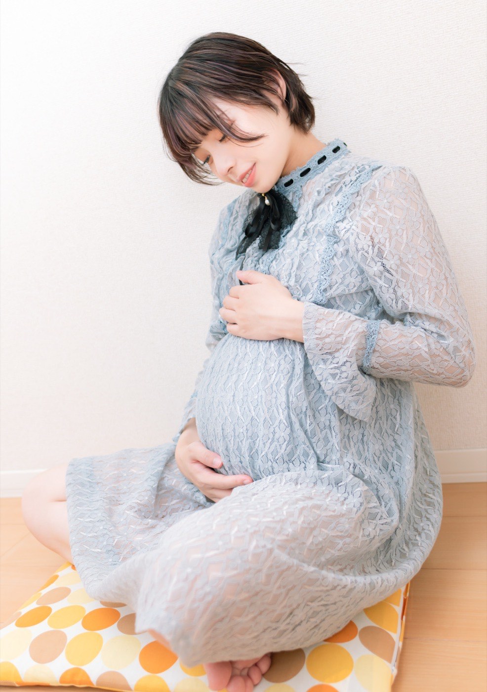 臨月のおなかを両手で触る妊婦さん